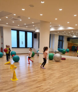 Kinder spielen mit Bällen in einer Halle