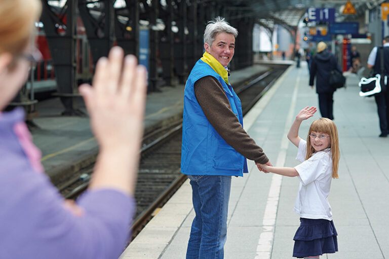 Ältere grauhaarige Dame führt ein Kind an der Hand